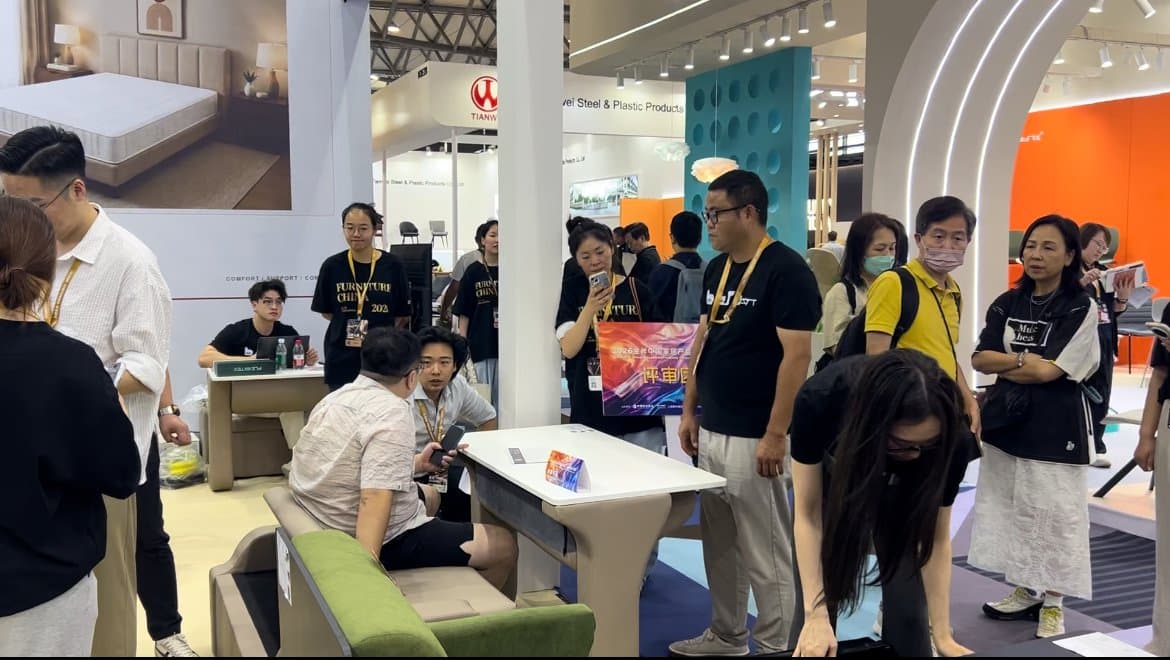 Visitors talking and exploring furniture at the LMFU exhibition booth